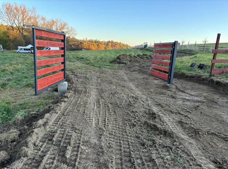 Brána na nepovolených betonových patkách na orné půdě